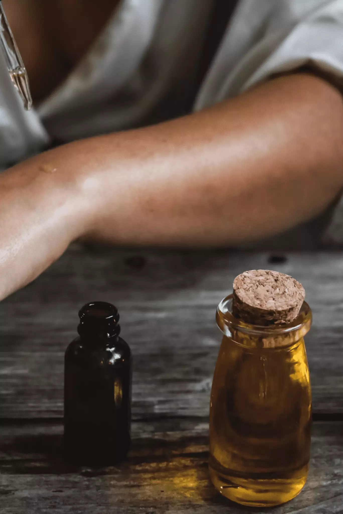 Flacons d'huiles essentiels devant un bras testeur